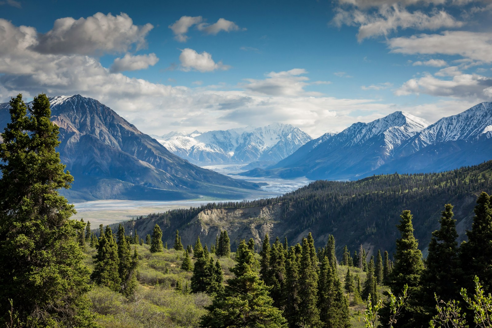 A mountain range rising above a wide alpine valley